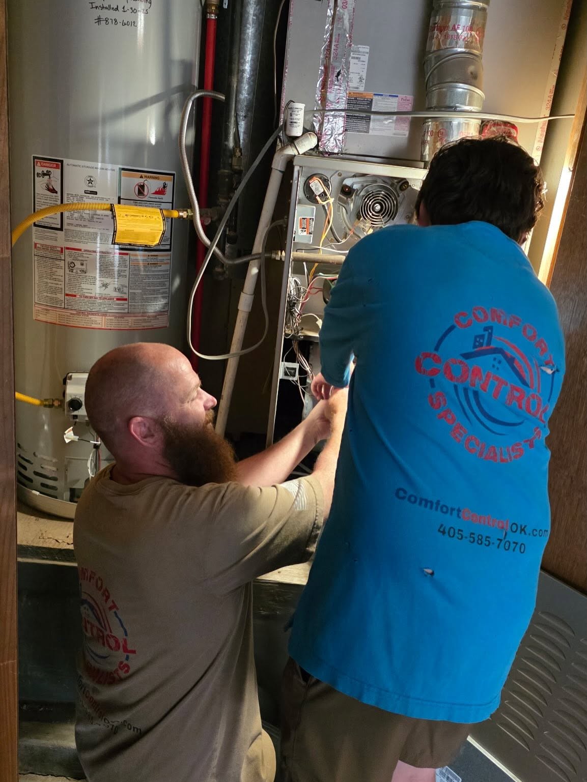 Comfort Control Specialists HVAC technician servicing residential HVAC equipment in Oklahoma