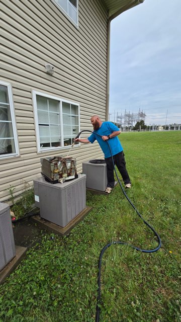 Comfort Control Specialists technician repairing an HVAC system for a homeowner